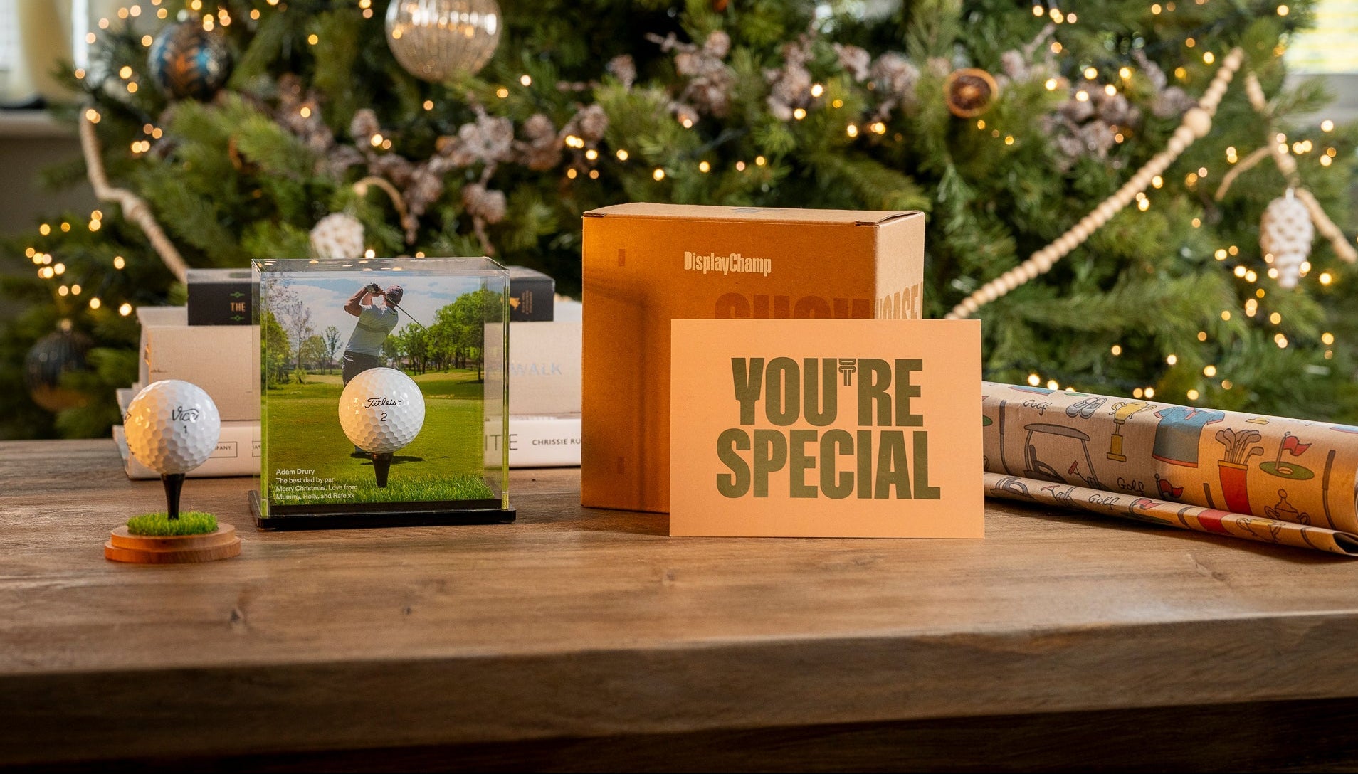 Golf-themed gift set with 'You're Special' card in front of a decorated Christmas tree.