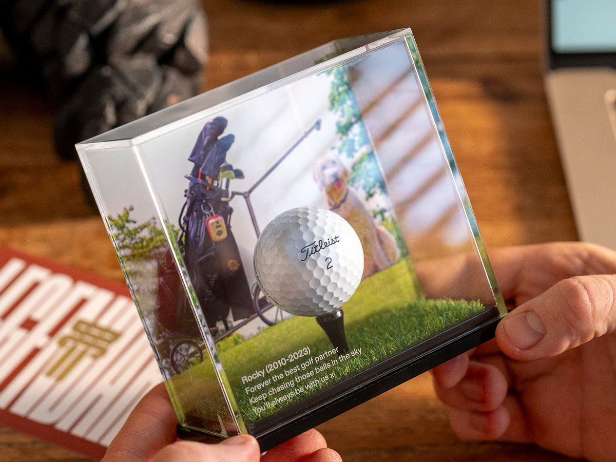 Person holding a custom background golf ball display case by Display Champ