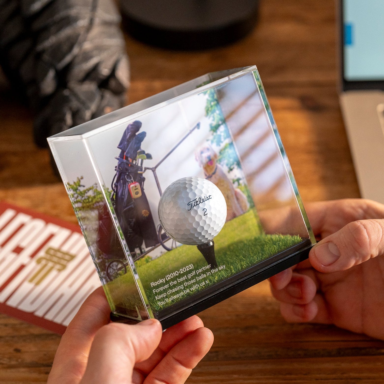 Person holding a custom background golf ball display case by Display Champ