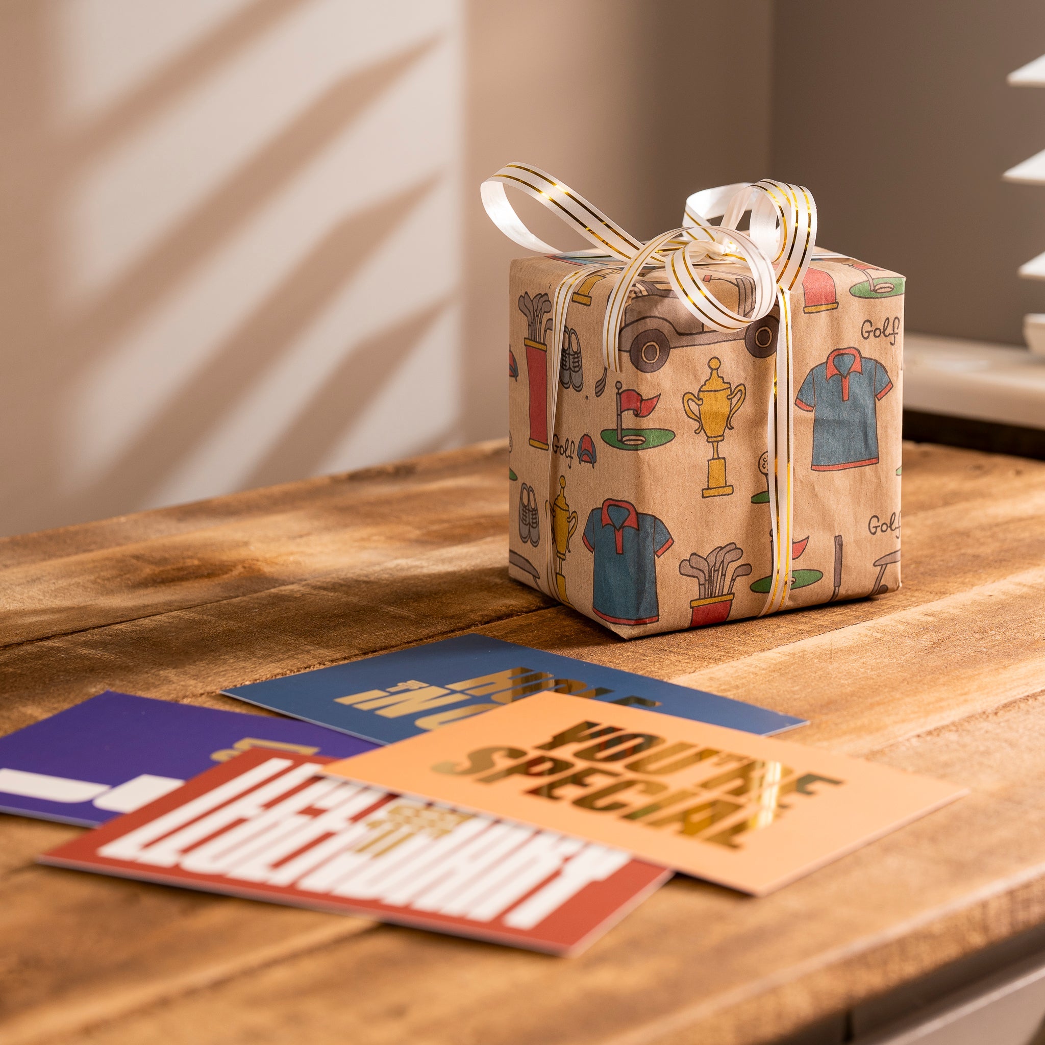 a gift wrapped in a paper with a ribbon and a bow on a table