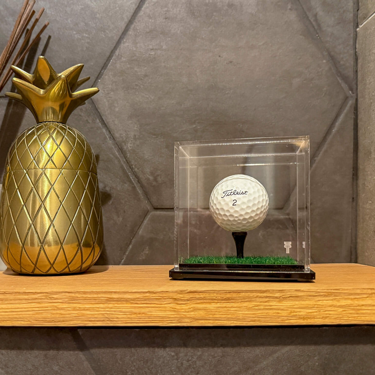 a pineapple and golf ball in a case