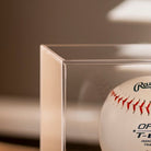 Baseball in a clear display case with a blurred background